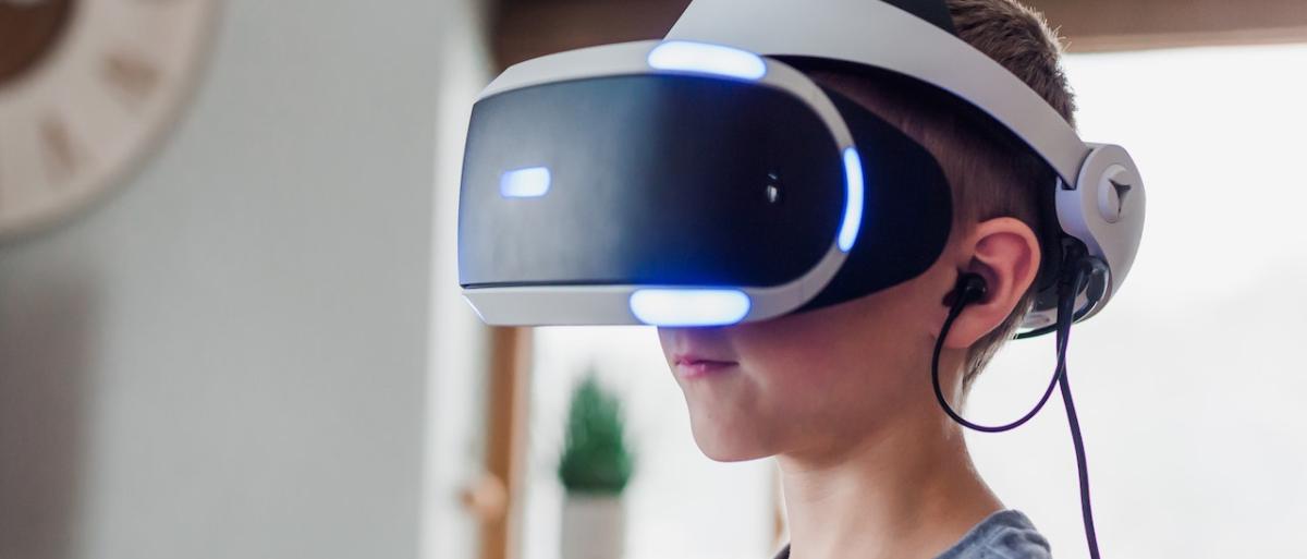 Young boy wearing a virtual reality headset and smiling