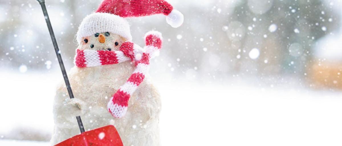 SNOWMAN WITH CHRISTMAS CAP AND SHOVEL IN SNOW