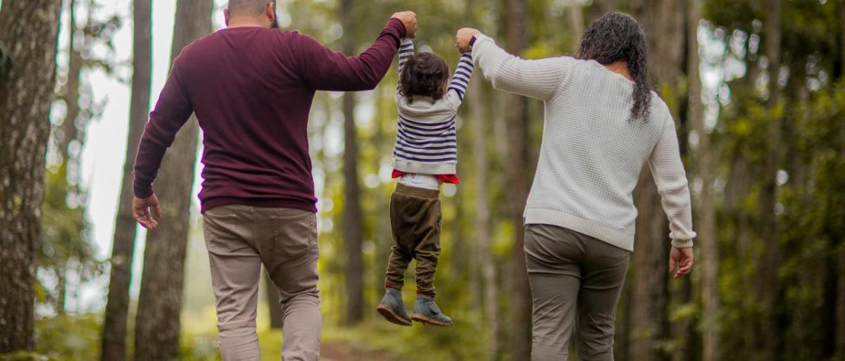 A father, mother and child holding each other