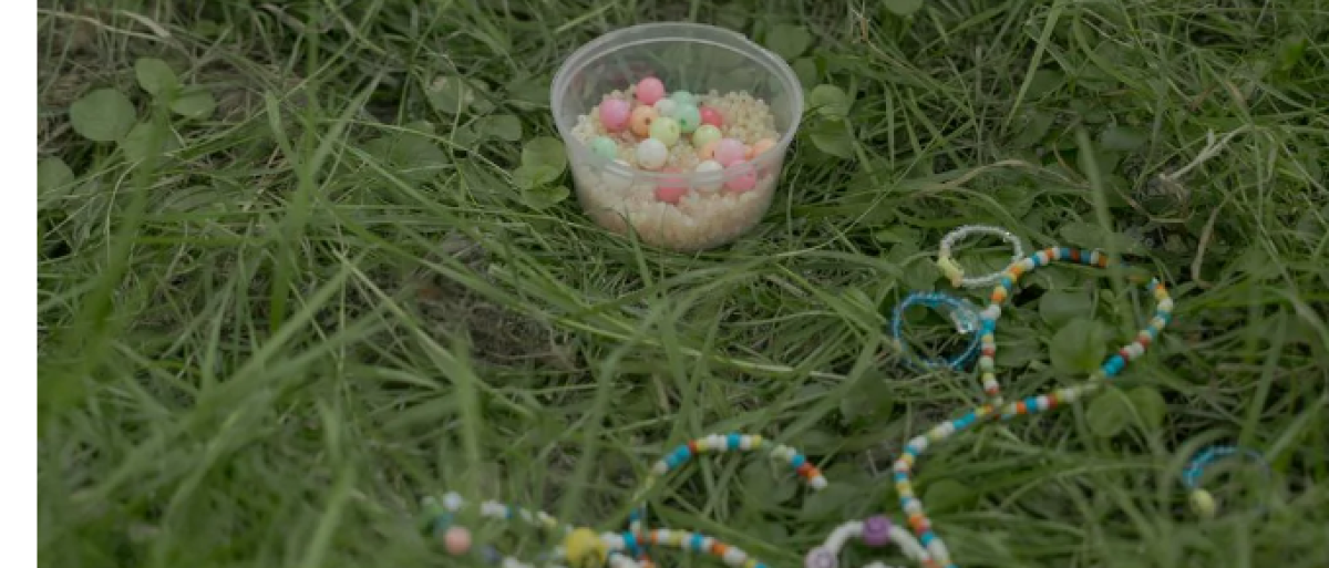 Beads in a jar and in a string on the grass