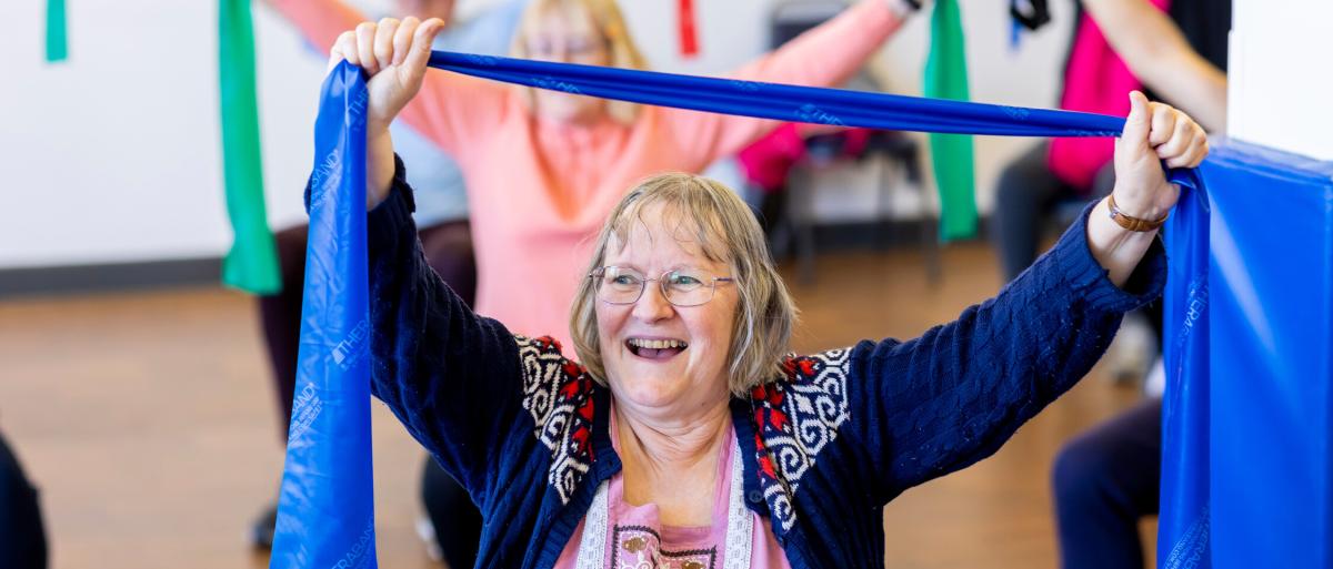 Older woman doing chair based exercise