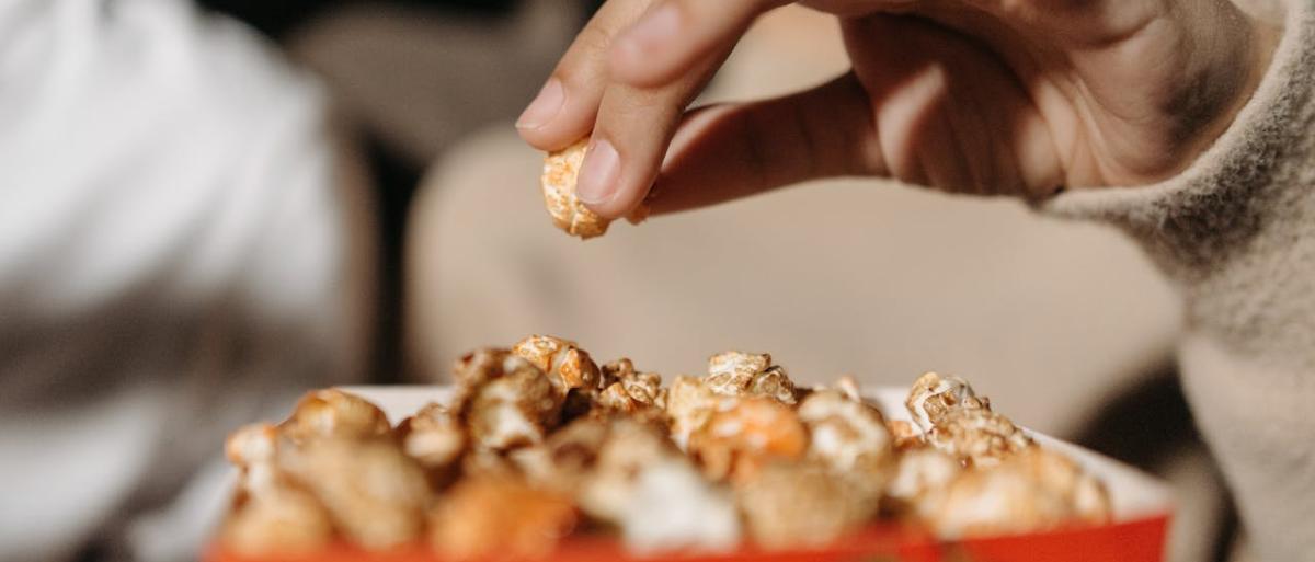 Someone picking popcorn to eat