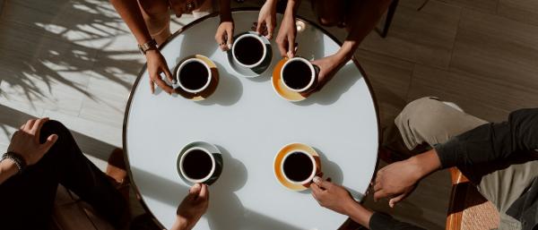 People sitting around a table having a coffee together