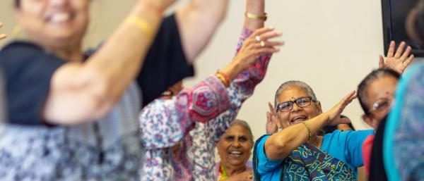 Women doing a seated exercise class together, smiling