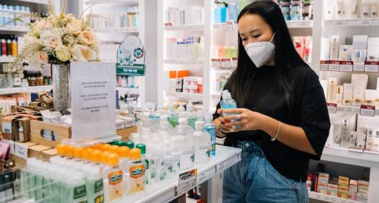 Woman wearing a mask at a pharmacy looking at items