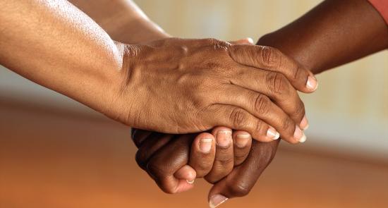 Two people holding hands in a show of support