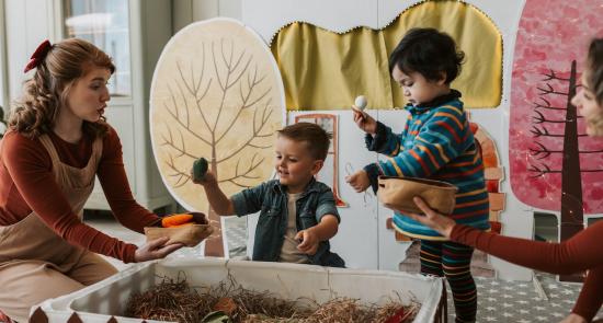 Children playing in a nursery with a nursery worker