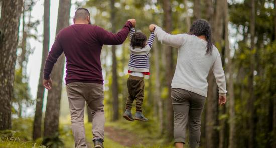 A father, mother and child holding each other