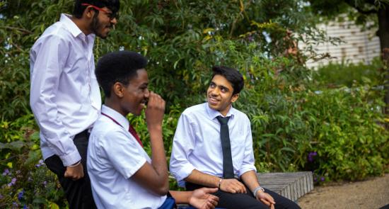 Teenage boys chatting together and laughing in the park